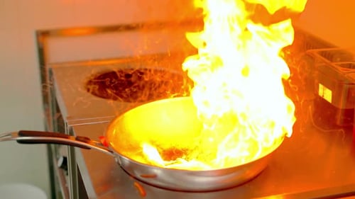 Chef Flambéing Colorful Vegetables in Commercial Kitchen