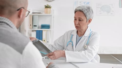 Doctor Explains X-Ray to Patient in Office