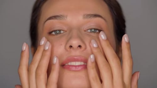 Woman Massaging Face in Beauty Close Up