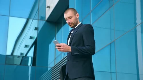 Handsome Businessman Using Smartphone Near Office