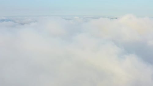 The Drone Rises From the Thick Fog Over the Beautiful Ocean of Clouds at Dawn