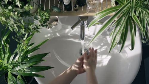 Femme lavant les mains dans la salle