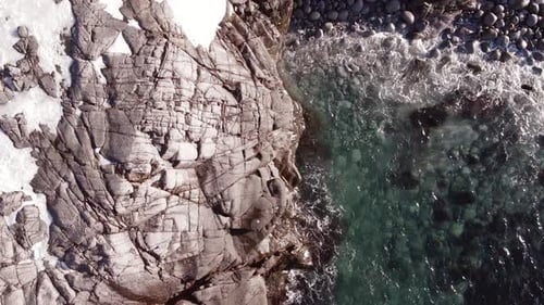 Winter Aerial Flight Top Over Waves Rolling on Artic Ocean Shore with Round Stones Ocean Waves at