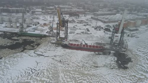 Winter sea port with cargo ship and cranes
