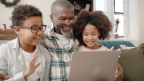 Grandfather and Grandchildren Video Conferencing on Laptop