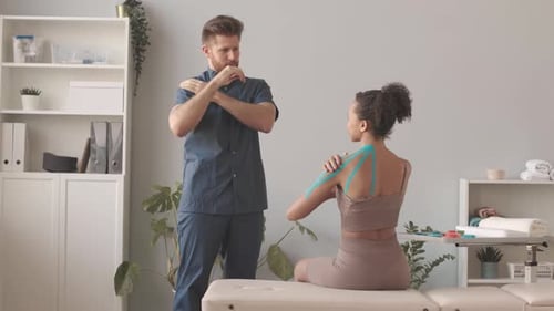 Therapist Demonstrates Shoulder Exercise with Patient