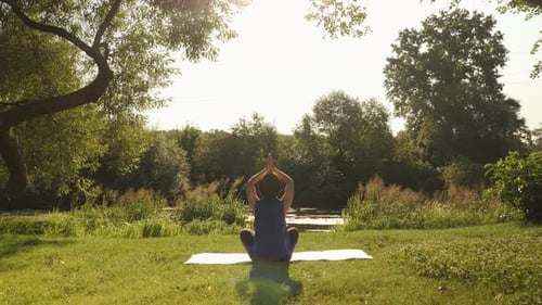 Woman Practicing Yoga Outdoors in Peaceful Nature Setting