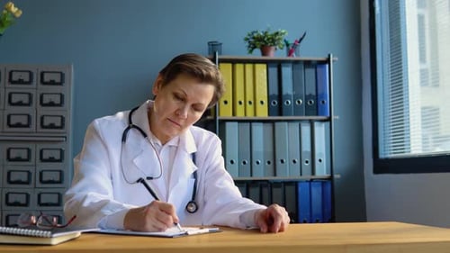 Doctor Writing on Clipboard at Office Desk