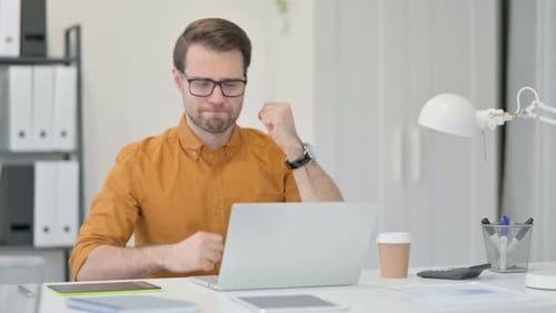 Young Man Having Loss on Laptop in Office