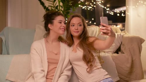 Smiling Women Taking Selfie with Mobile Phone at Night