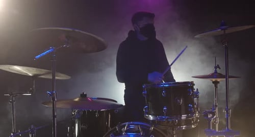 Drummer Playing Drums in Smoky Dark Environment