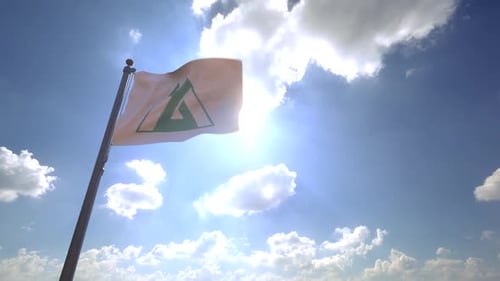 Flag with Green Mountain Logo Waving Against Sunny Blue Sky
