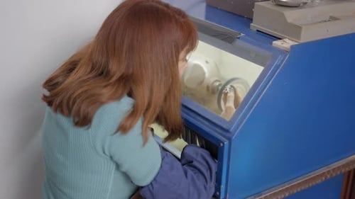 Female Jeweler Using An Electric Grinding Table Polisher