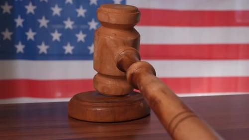 Um martelo de juiz com uma bandeira dos Estados Unidos da América em segundo plano