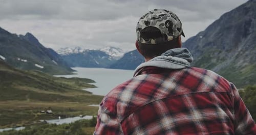 Man In Cap Looking At View Of Lake And Mountains