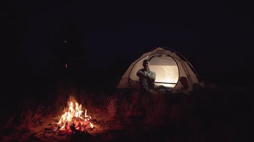 Camping at Night near Tent and Campfire