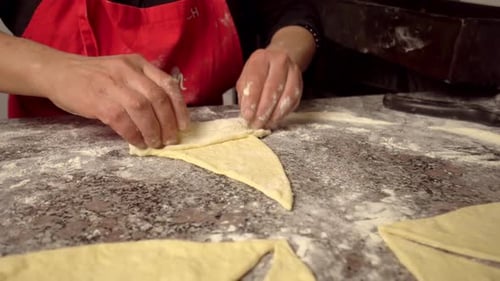 Frau dreht Stücke und bereitet Croissant vor