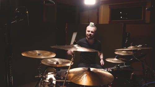 Drummer performing in a studio setting.