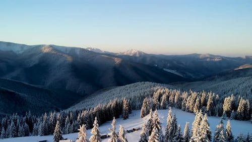 Flying Above Winter Mountain Valley at Sunrise