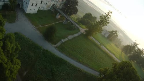 Colorful Hot Air Balloons Fly Over the Medieval Castle and Lake in the Morning Fog. Maneuverable