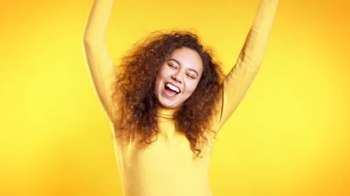 Young Cute Girl Dancing on Yellow Studio Background. Woman Colorful Bright Wear