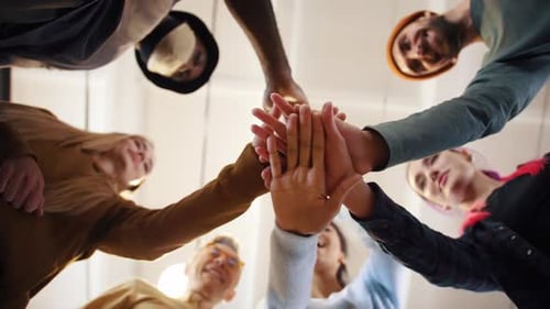 Group of Young Adults Putting Hands Together Teamwork