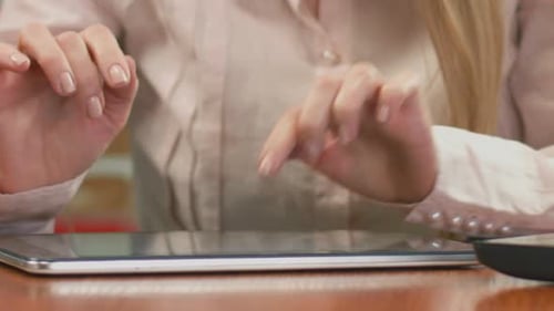 Female Economist Working on Tablet, Typing Weekly Report. Close-Up of Hands