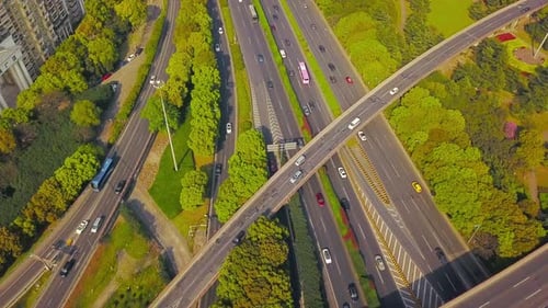 Aerial view of cars on highway junctions with green trees. Bridge roads or streets in structure