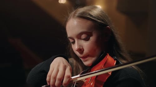 Young Beautiful Female Violinist in Symphonic Orchestra Woman is Playing Violin in Music Hall