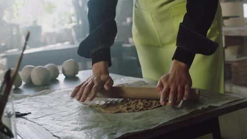 Potter Rolling Clay on a Table in Studio