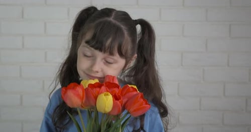 Happy Girl Smelling Colorful Tulips Bouquet Indoors