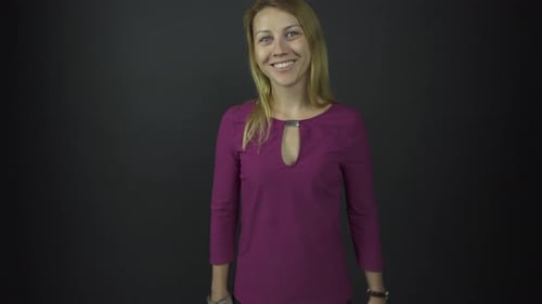 Smiling Woman Poses Against Gray Backdrop