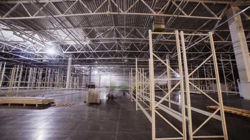 Les employés assemblent des racks de pièces métalliques dans un entrepôt d'usine