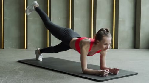 Woman Exercising Core with Leg Lifts in Plank