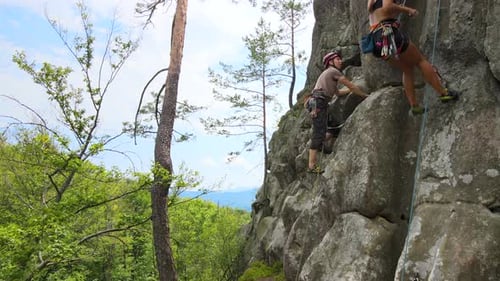 Starker männlicher Kletterer klettert auf die steile Wand des Rocky Mountain