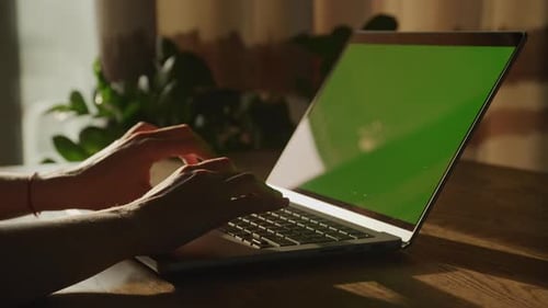 Cerrar las manos de una mujer caucásica descansando y escribiendo en una computadora portátil con clave de croma de pantalla verde