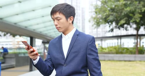 Young Adult Using Smartphone in Urban Park