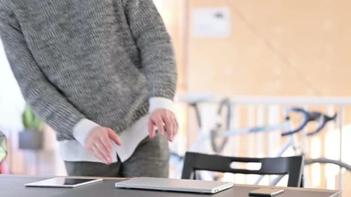 Young Adult Opening Laptop at Desk