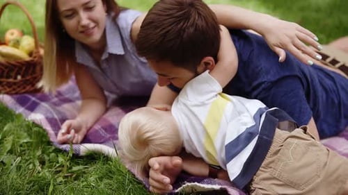 Family Enjoys Picnic in Green Grassy Field