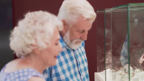 Happy Aged Man and Woman Standing Near Showcase with Jewelry
