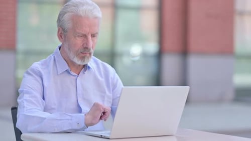 Senior Man Using Laptop, Looking Thoughtful