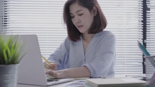 Young Adult Woman Working at Desk With Laptop