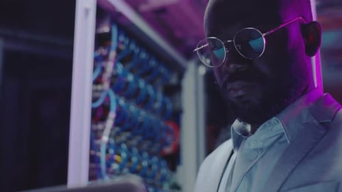 African American Data Center Engineer Working in Server Room