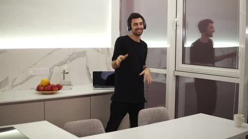 Man Dancing to Music in Modern Kitchen