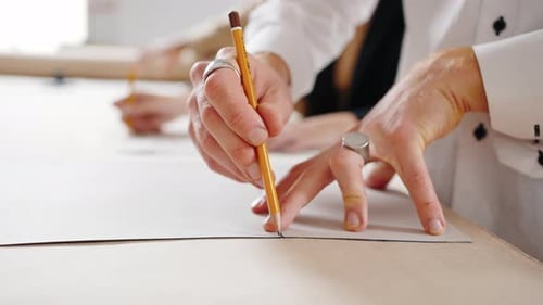 Designer Tracing Pattern with Pencil in Workshop
