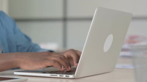 Close Up of Young African Man Typing on Laptop