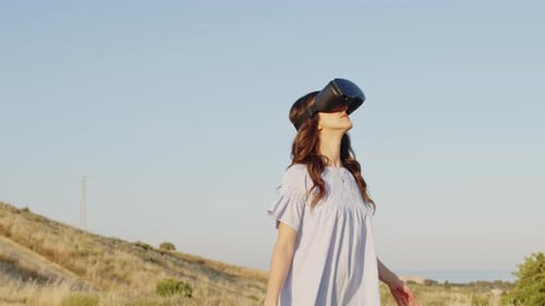 Woman Uses VR Headset in Rural Landscape