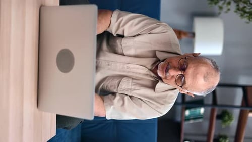Senior Man Working on Laptop Computer at Home