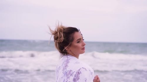 Girl Walks on the Beach on the Background of the Sea