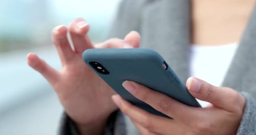 Woman Using Smartphone Close Up in Urban Setting
